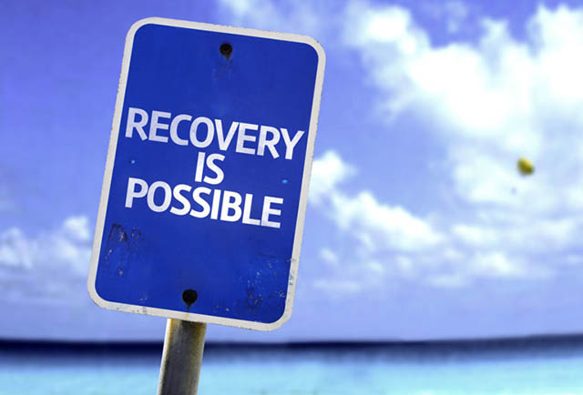 Recovery is Possible sign with a beach on background